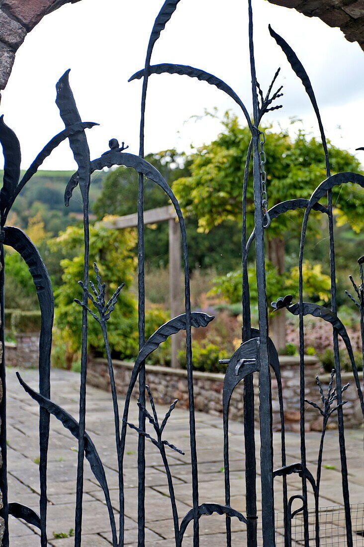 View through metal gate to kitchen garden, Blagdon, Somerset, England, UK