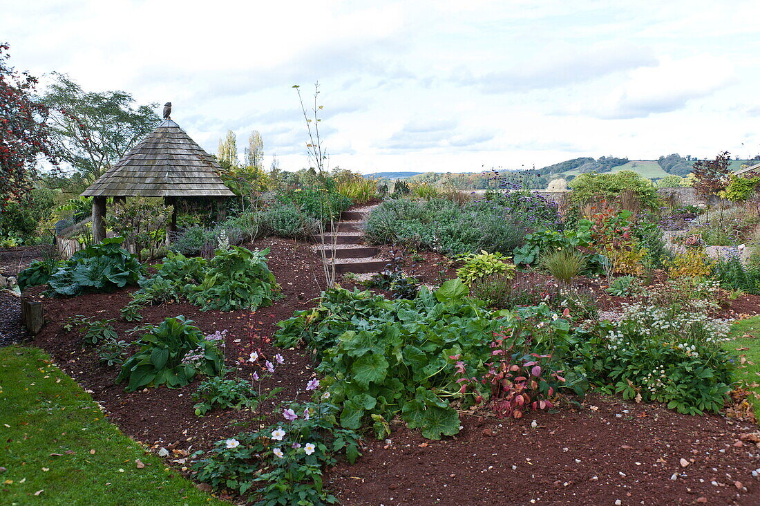 Garden structure and flowerbed in rural Blagdon, Somerset, England, UK