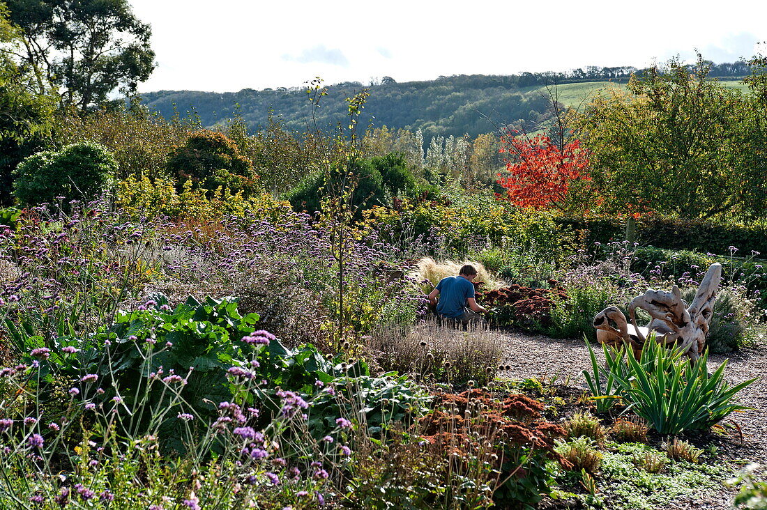 Unbekannte Person bei der Arbeit im Garten, Blagdon, Somerset, England, UK