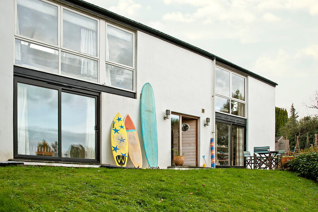 Surfbretter an der Außenseite eines modernen, weiß getünchten Hauses in Cornwall, UJ