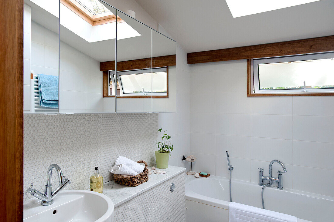 Weiß gefliestes Badezimmer mit Spiegelschrank in einem Haus in Cornwall, UK