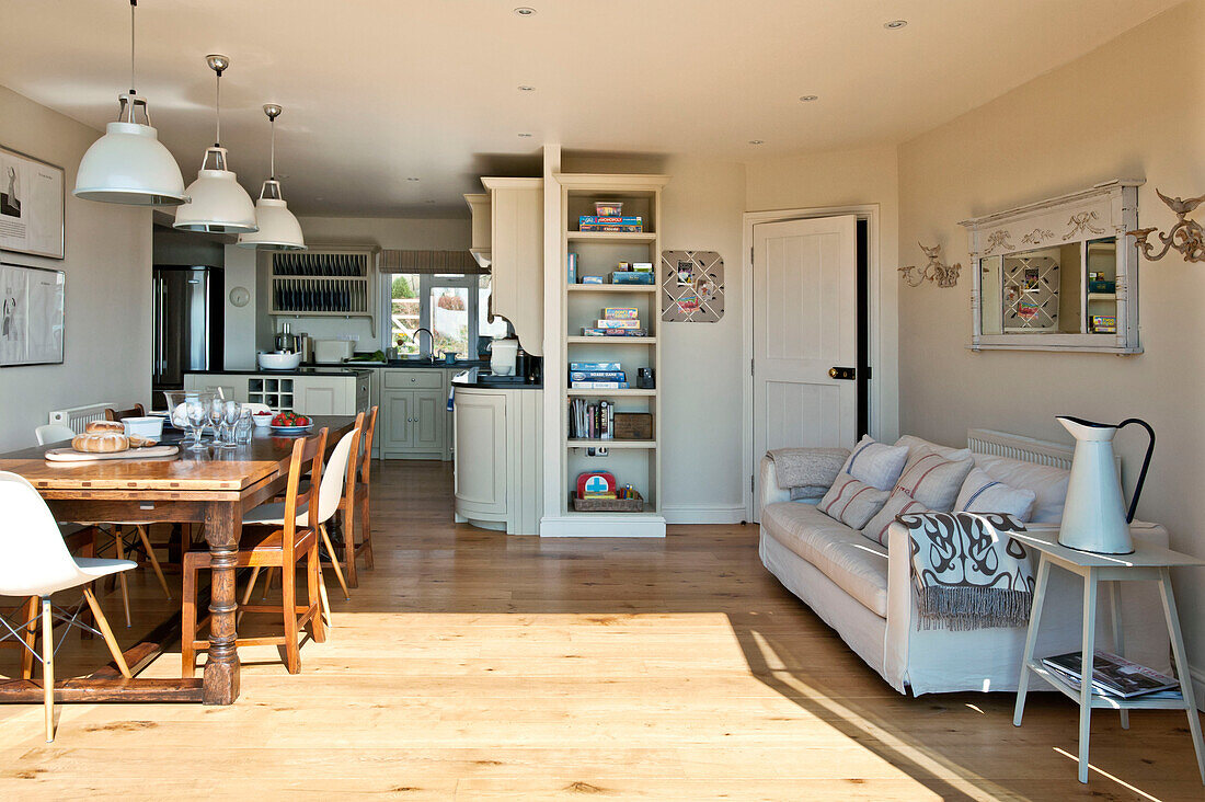 Sofa in offenem Esszimmer mit Regal in einem Einfamilienhaus an der Küste, Cornwall, UK