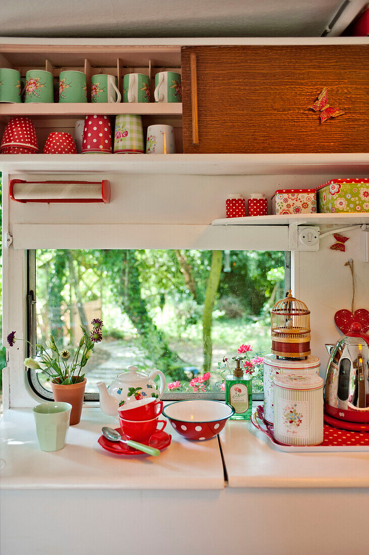 Küchenutensilien und Schrank am Fenster eines Wohnwagens