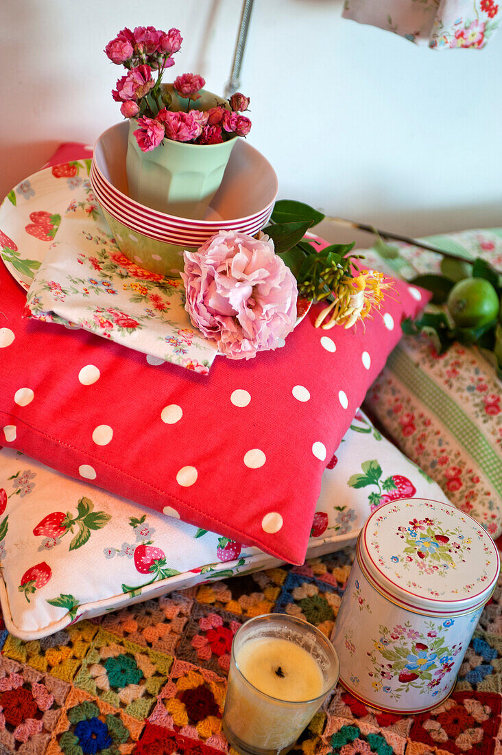 Carnations in bowls on cushions with storage tin in caravan