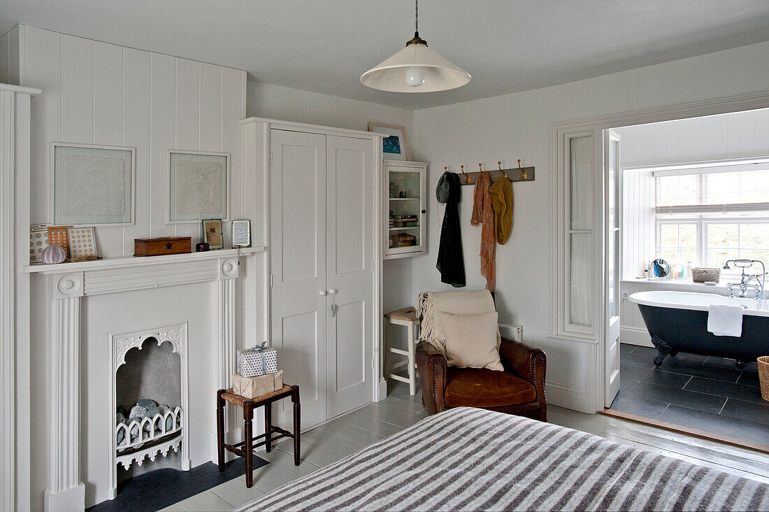 Badezimmer im Schlafzimmer mit braunem Ledersessel in einem Haus in Crantock, Cornwall, England, UK