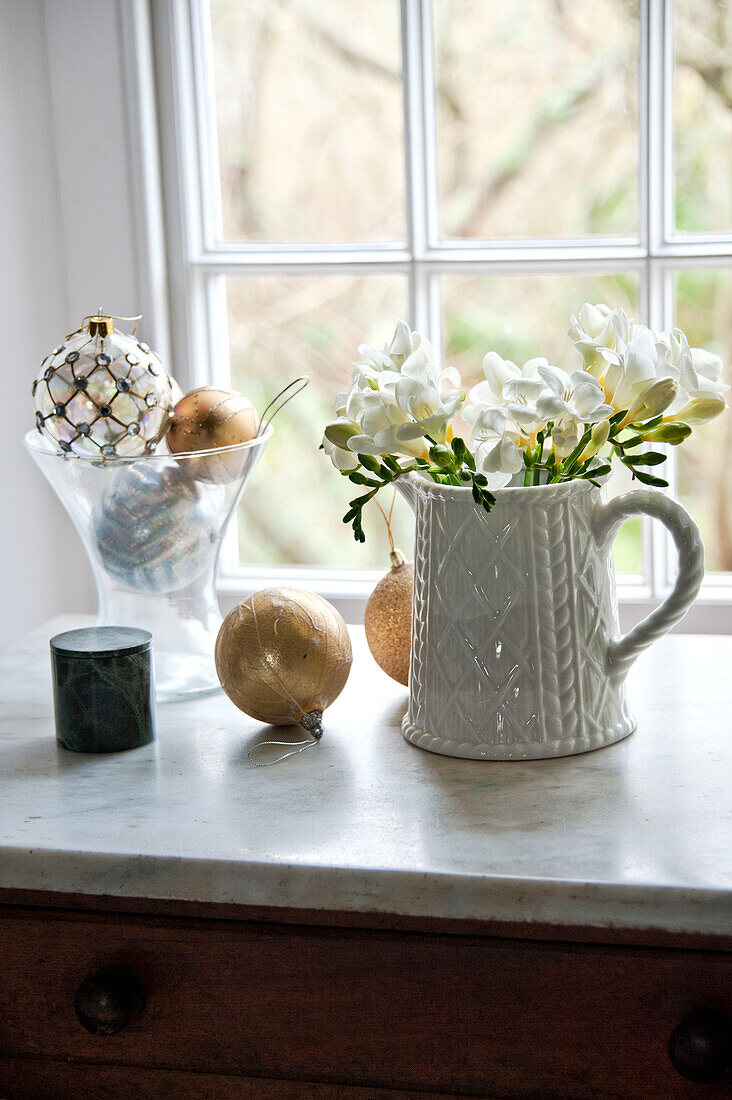 Schnittblumen in Keramikkrug mit Goldkugeln am Fenster in Crantock home Cornwall England UK