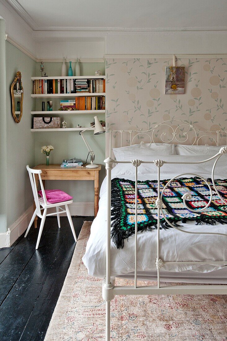 Schwarze Häkeldecke auf einem Doppelbett mit Schreibtisch und Bücherregal in einem Einfamilienhaus in Penzance Cornwall England UK