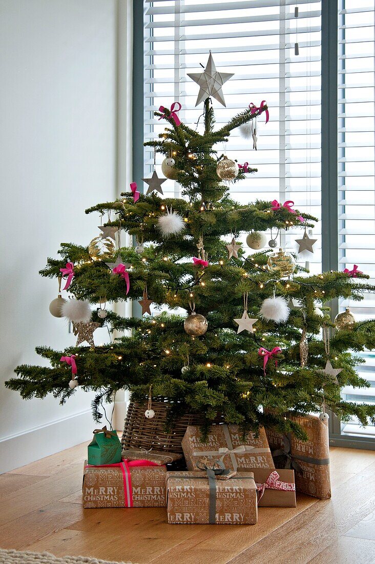Eingepackte Geschenke unter dem Weihnachtsbaum in einem Haus in Wadebridge, North Cornwall, Vereinigtes Königreich