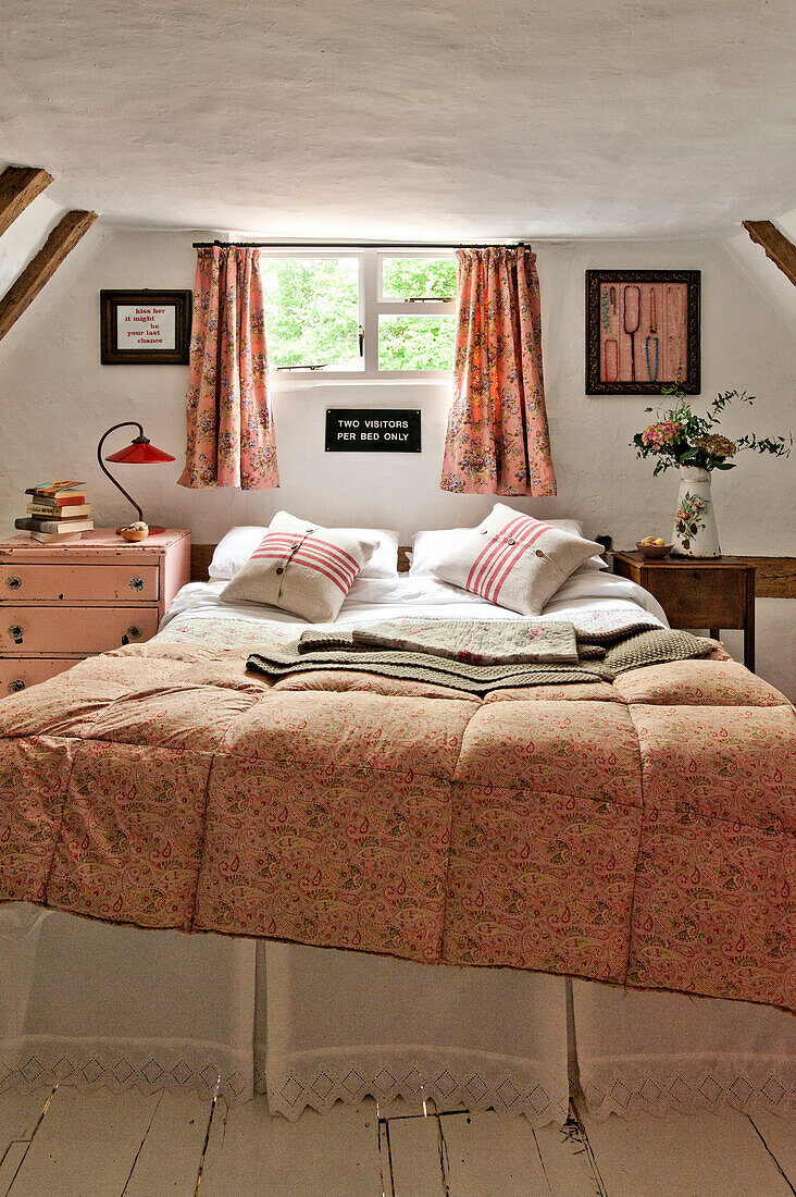 Doppelbett unter dem Fenster in einem Schlafzimmer mit Fachwerk in einem Cottage in Cambridge, England, Vereinigtes Königreich