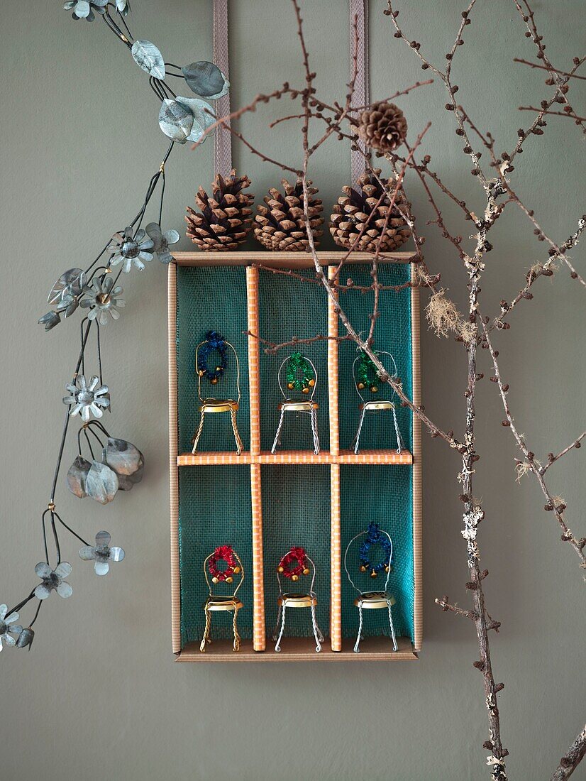 Bottle Top Stühle mit Tannenzapfen und Zweigen auf einem Wandregal in einem Londoner Haus in England UK