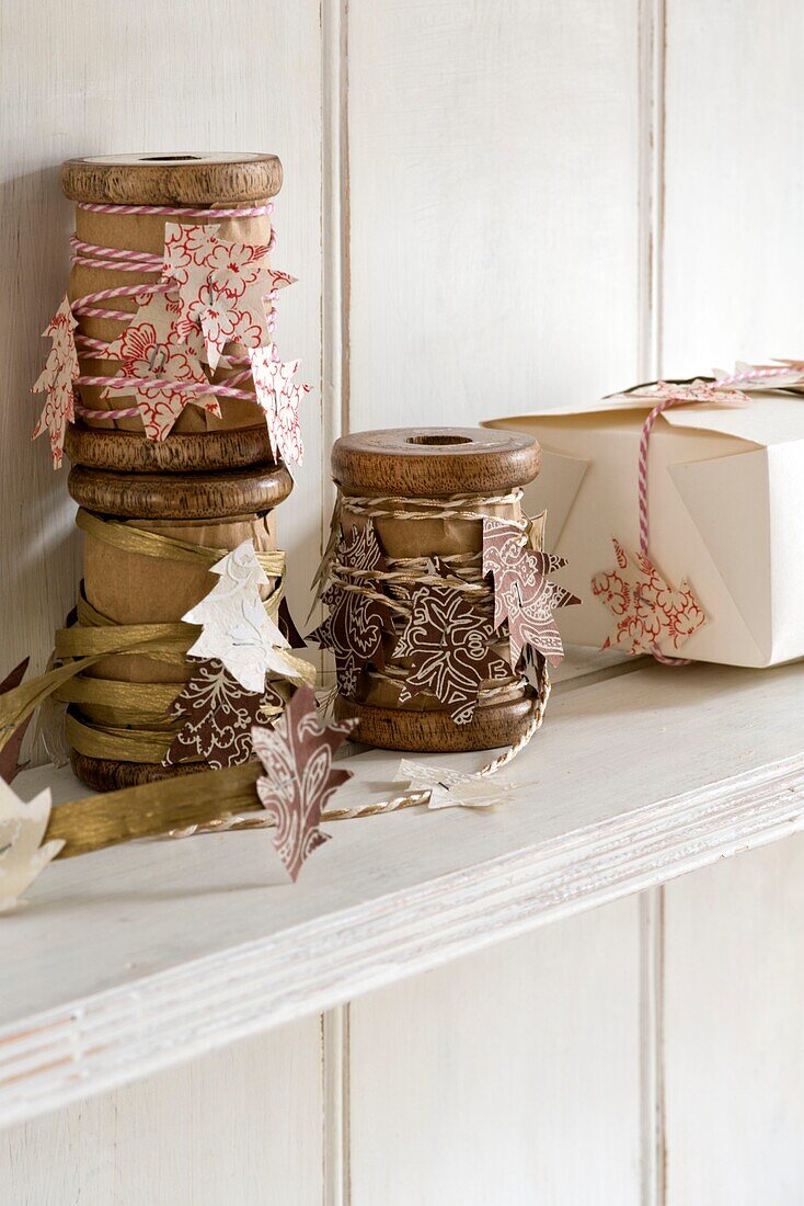 Vintage-Holzspulen mit ausgeschnittenen Weihnachtsbaumformen und Geschenkbox auf einem Regal in einem Londoner Haus England UK