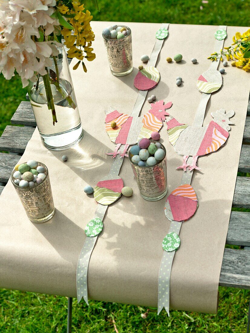 Easter eggs with cut out decorations on tabletop with brown paper in Sussex garden England UK