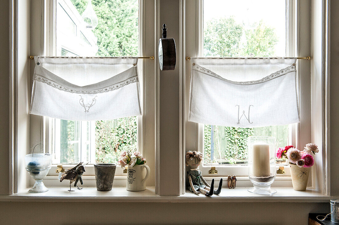 Bestickte Fenstertaschen über der Fensterbank mit alten Ornamenten in einem Haus in Stamford Lincolnshire England UK