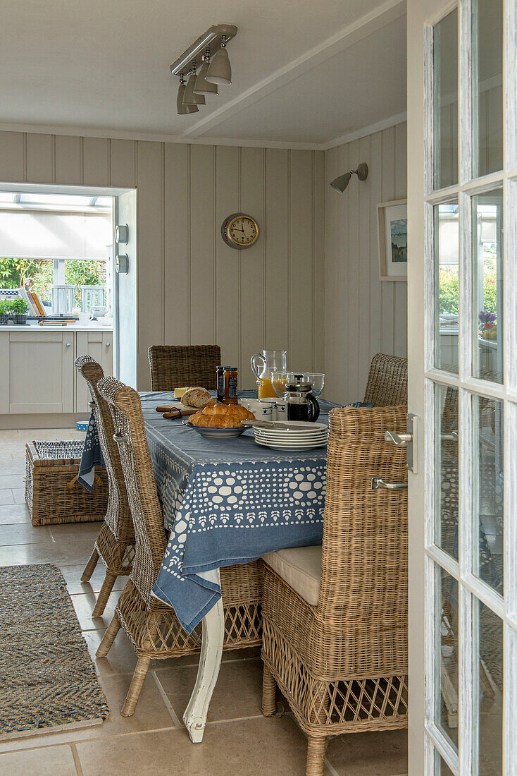 Frühstückstisch mit Korbstühlen in einem getäfelten Bauernhaus in Penzance, Cornwall, England UK