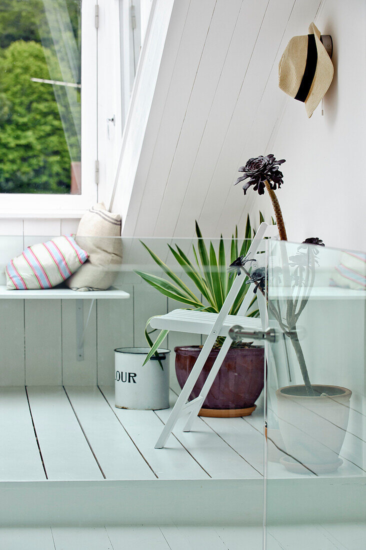 Window seating with houseplants in attic conversion of family townhouse Cornwall England UK