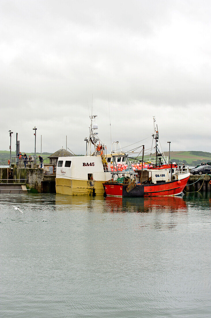 Fishing boats moored in harbour with overcast sky Cornwall UJ