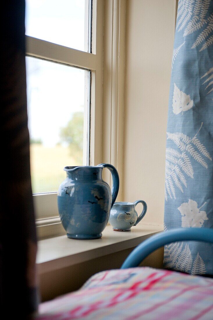 Blaue Keramikkrüge auf der Fensterbank in einem Schlafzimmer in Edworth Bedfordshire England UK