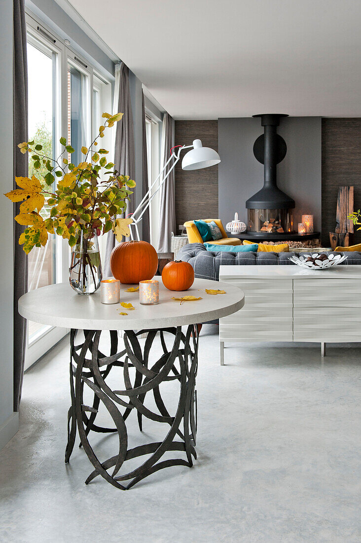 Leaf arrangement and pumpkins on metalworked side table in Lechlade living room Gloucestershire England UK