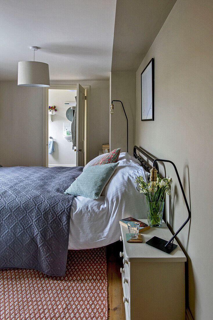 Grauer Bettbezug auf einem Doppelbett mit eigenem Bad in einem Haus in St Ives, Cornwall, Vereinigtes Königreich