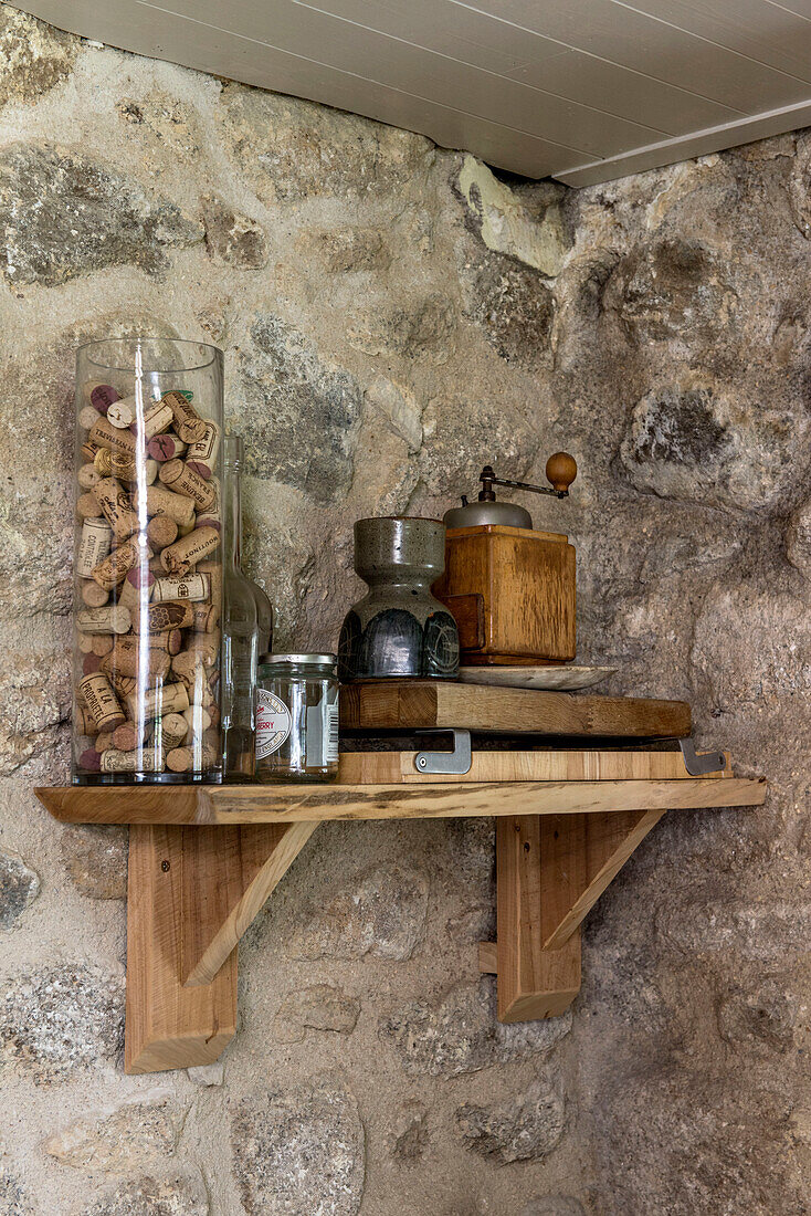 Sammlung von Korken mit alter Kaffeemühle auf einem Regal in einer Bauernhausküche aus Naturstein in Helston, Cornwall, Großbritannien