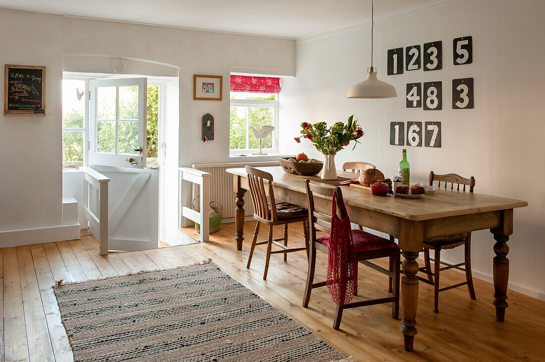 Wooden dining table with numerals in split level Cornwall cottage UK