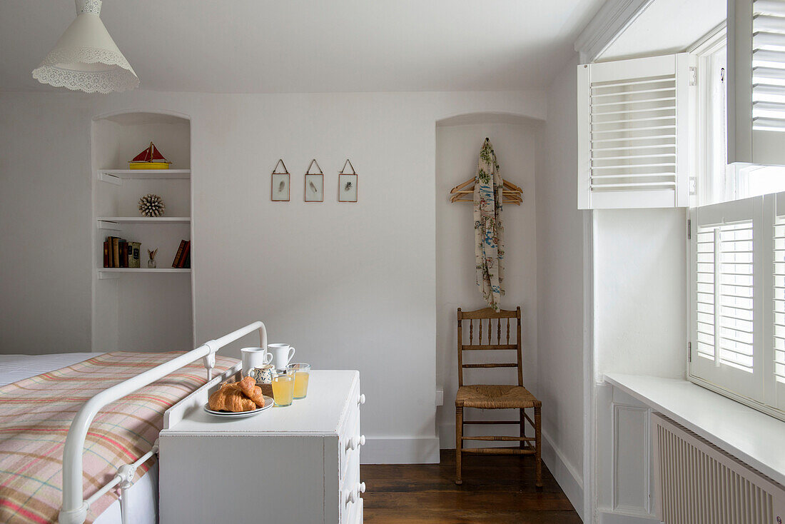 Storage alcoves in Cornwall bedroom with breakfast croissants at food of double bed UK