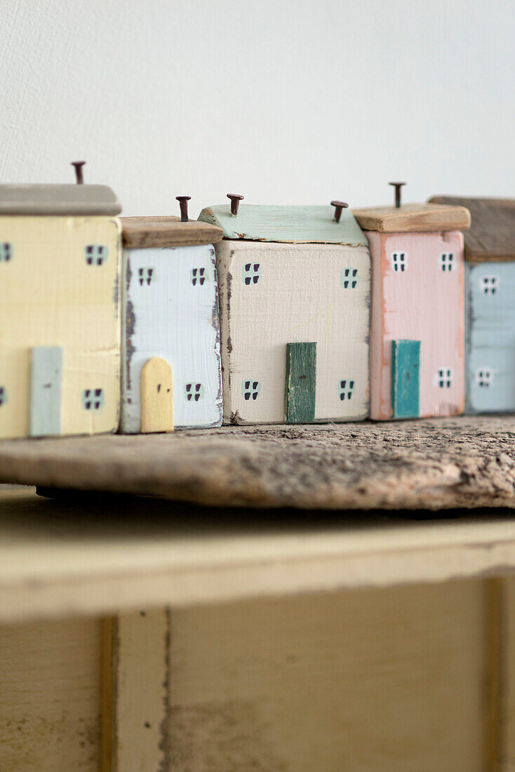 Row of hand painted houses with nails for chimneys Cornwall UK