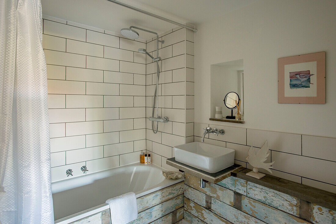 Duscharmatur in einem weiß gefliesten Badezimmer mit Holzverkleidung in Cornwall, Großbritannien