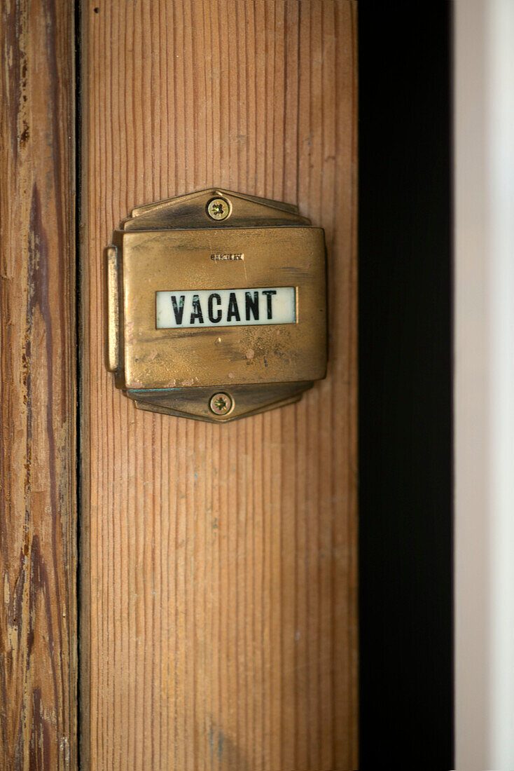 'Vacant' brass lock on wooden door Cornwall UK