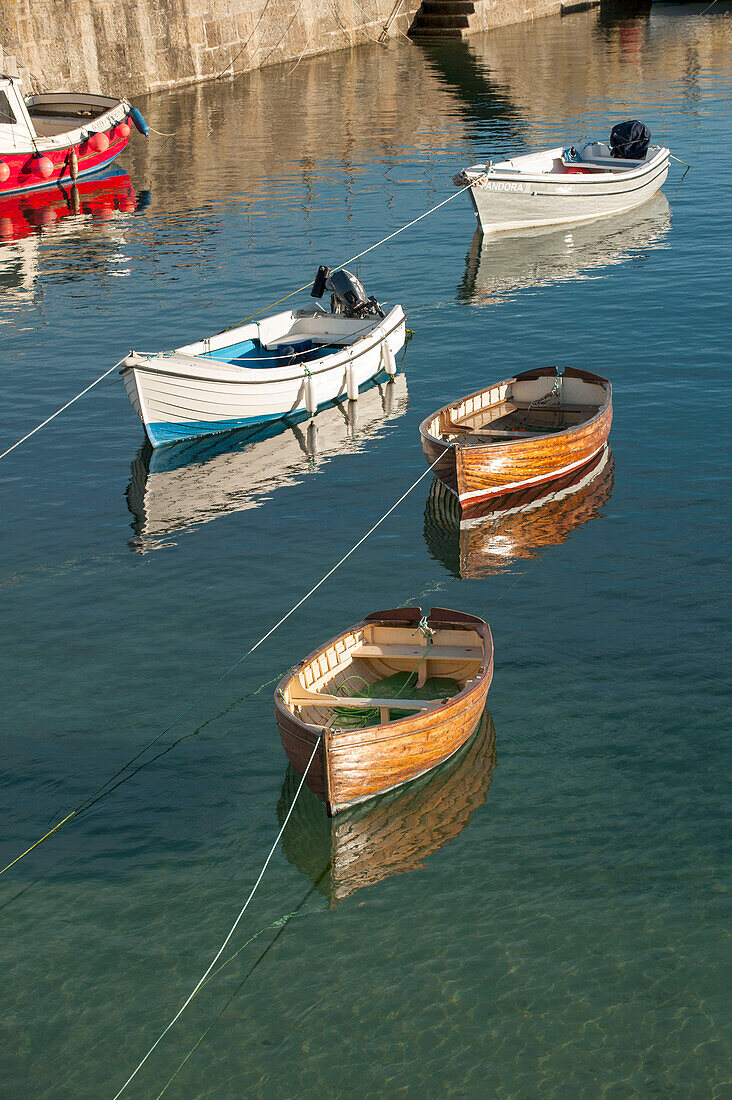 Rowing boats moored in Mousehole harbour Cornwall UK