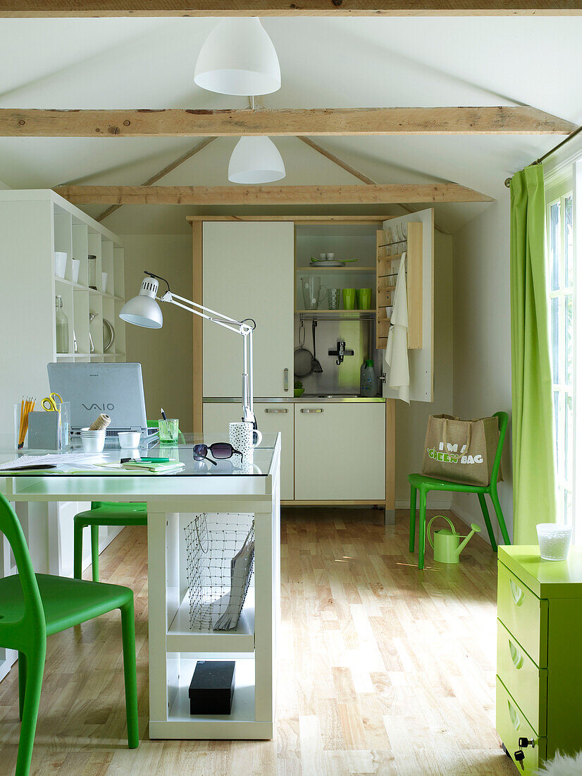 Green chairs and kitchen unit in self-contained summerhouse work studio UK