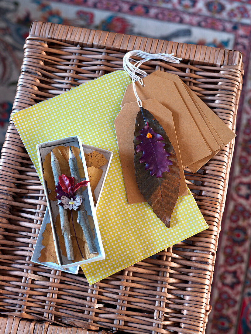 Bleistifte in Geschenkbox mit Anhängern und Blattdekoration auf Weidenkorb in einem Haus in Großbritannien