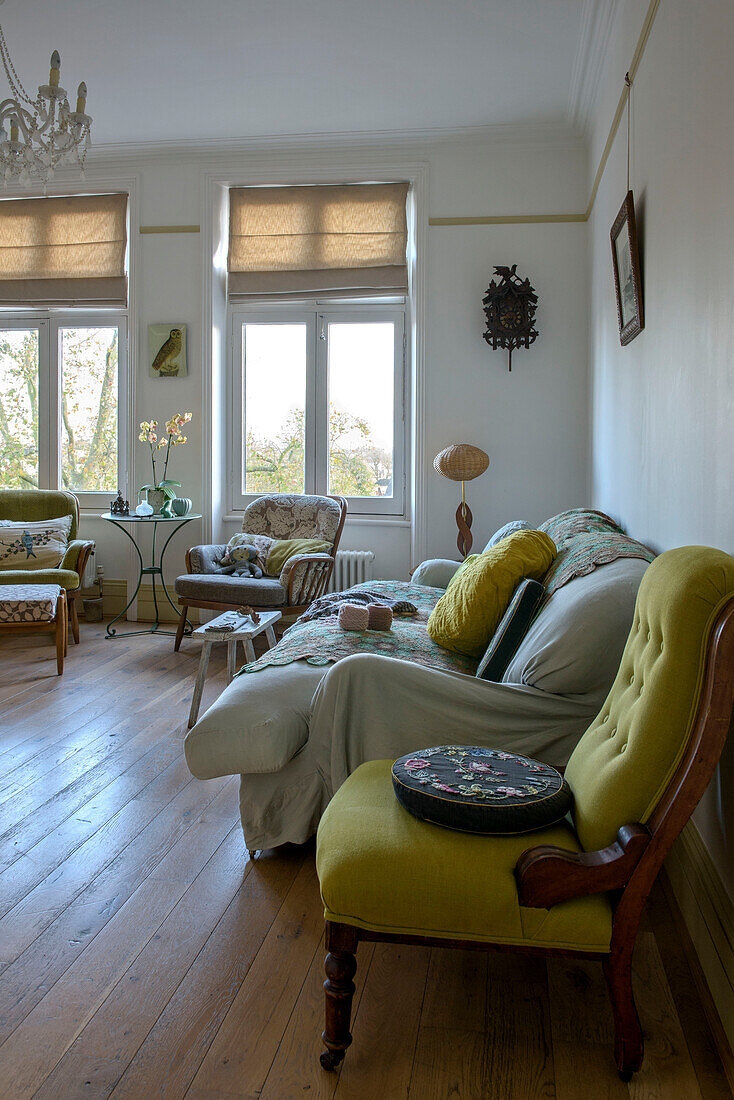 Gobelin-Kissen auf gelbem Stuhl mit cremefarbenem Sofa in einer Wohnung in London UK