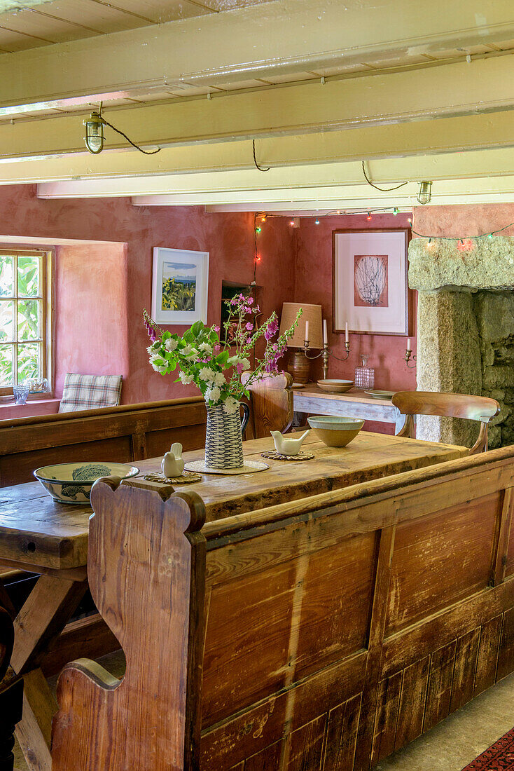 Schnittblumen auf einer altmodischen Holzbank und einem Tisch in einem Bauernhaus in Helston, Cornwall UK