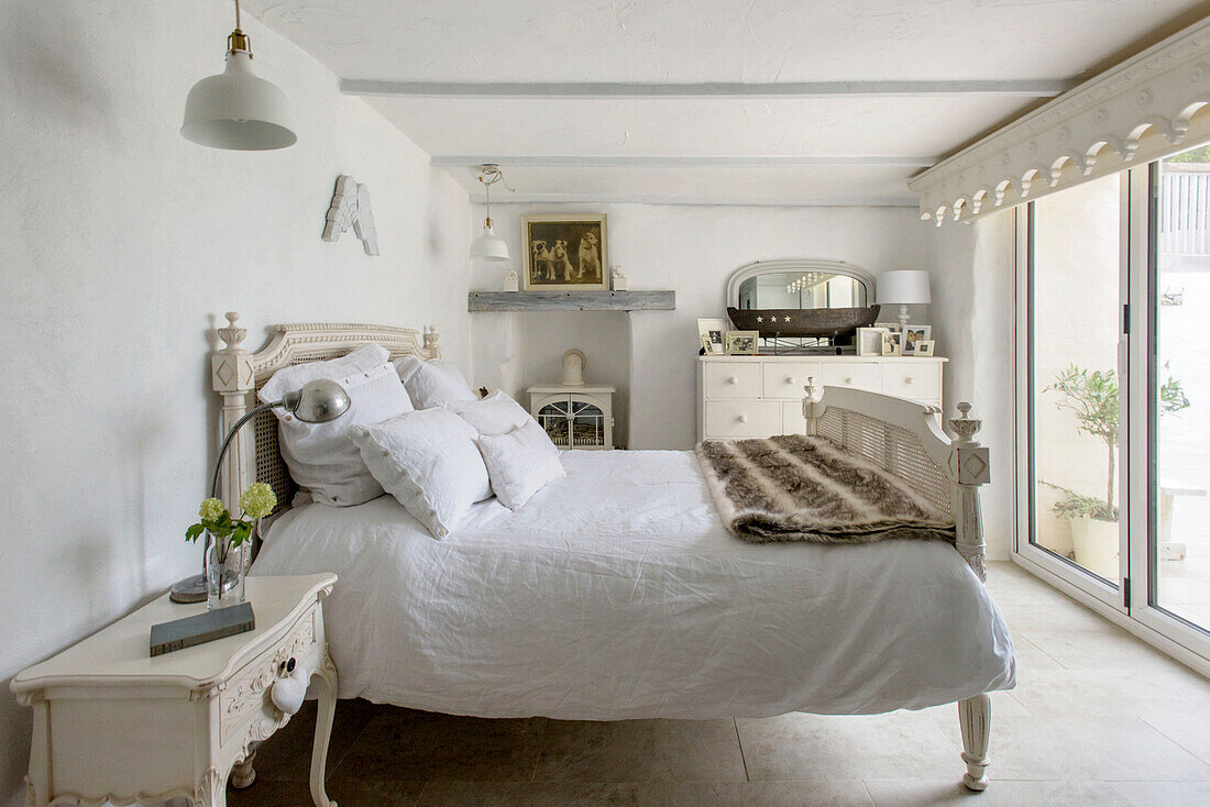 Pelzteppich auf weißem Doppelbett in einem Strandhaus in Marazion, Cornwall, Großbritannien
