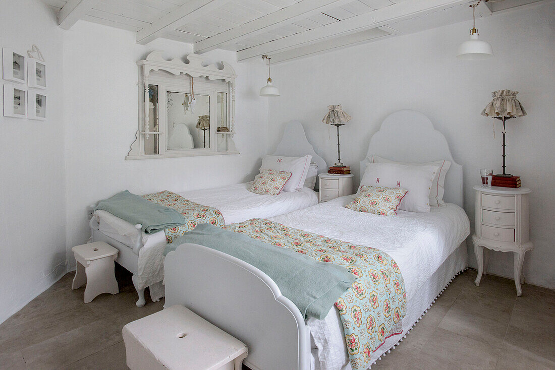 Twin beds with light blue blankets and floral quilts in Marazion beach house Cornwall UK