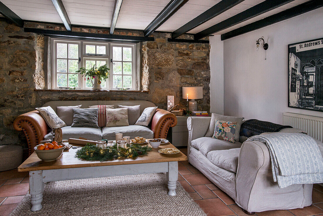 Leather sofa with coffee table cut down from a dining table in St Erth cottage Cornwall UK