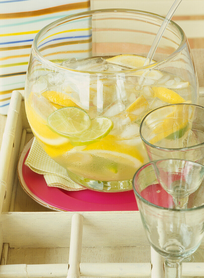 Glass bowl with lemonade and glasses 