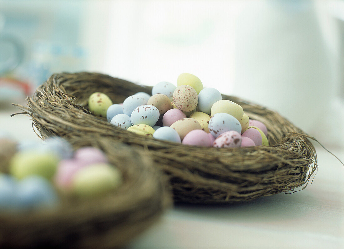 Colourful sugar coated chocolate Easter eggs in bird's nest shaped basket
