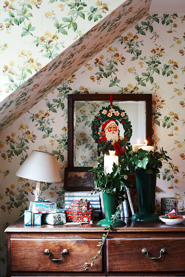 Evergreens and ivy on vintage wooden chest with floral wallpaper in Shropshire cottage England UK