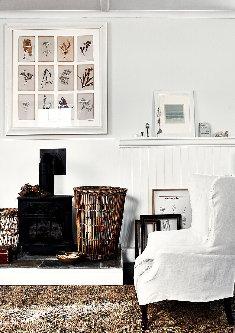 Sessel am Kamin mit gerahmten Kunstwerken im Haus in Lyme Regis Dorset UK