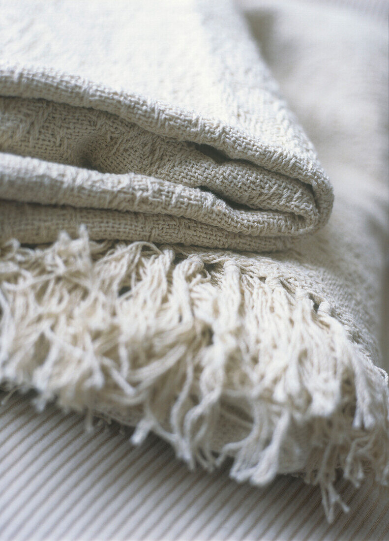 Detail of cream cotton blanket with fringe