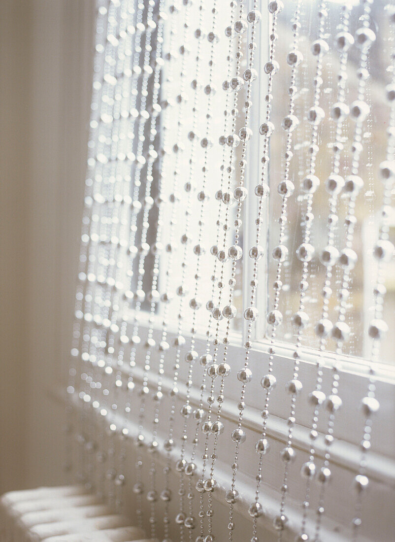 Silver beaded curtain at window