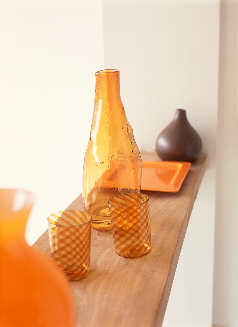 Auslage mit zeitgenössischen orangefarbenen und braunen Glaswaren und Keramiken auf einem Regal