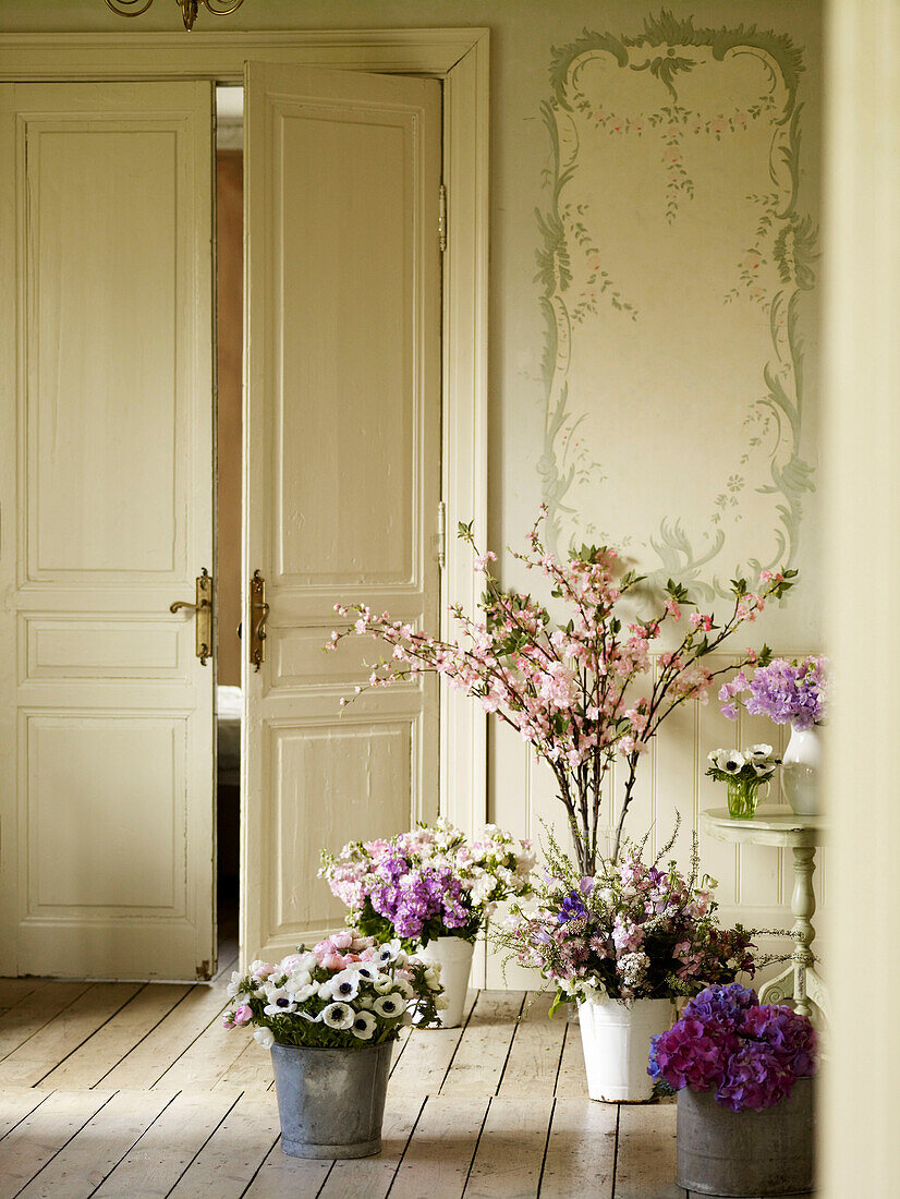 Eimer mit Schnittblumen in einem Raum mit Flügeltüren