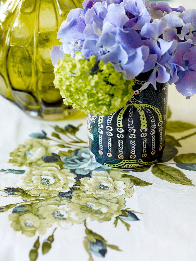Cut flowers in vintage vase on floral tablecloth