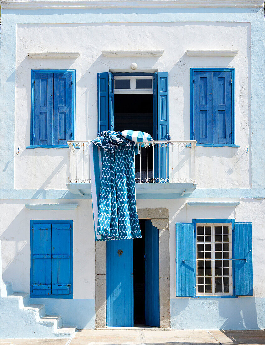 Belüftung von Beeten auf dem Balkon einer griechischen Villa mit blau gestrichenen Fensterläden