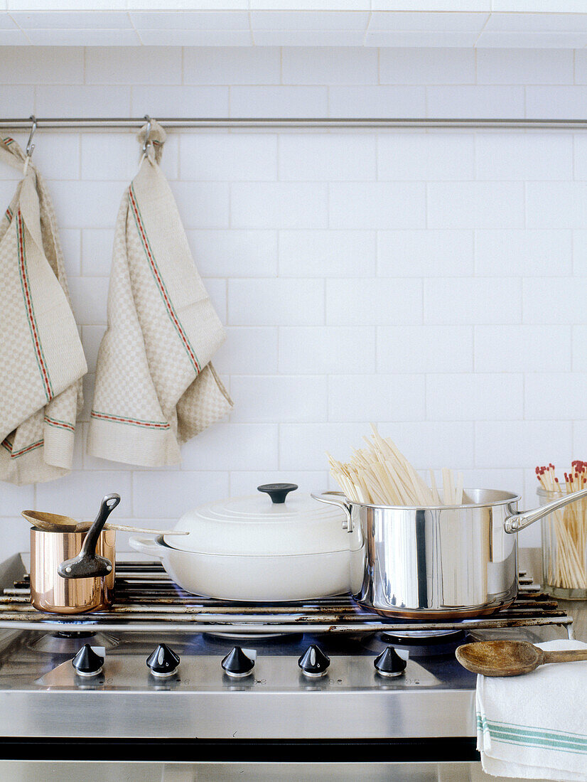 Assorted pans on gas hob with dishcloths
