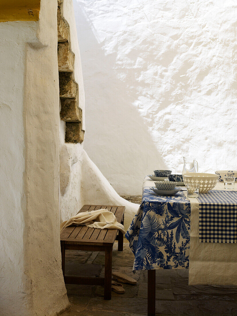 Blaue und weiße Tischdecken in einem weiß getünchten Innenhof Spanien