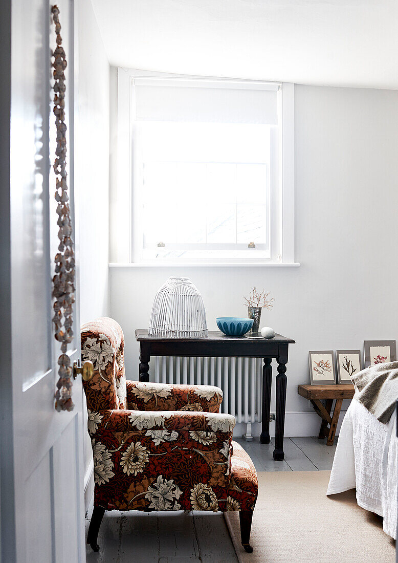 Vintage floral armchair in bright bedroom Lyme Regis home Dorset UK